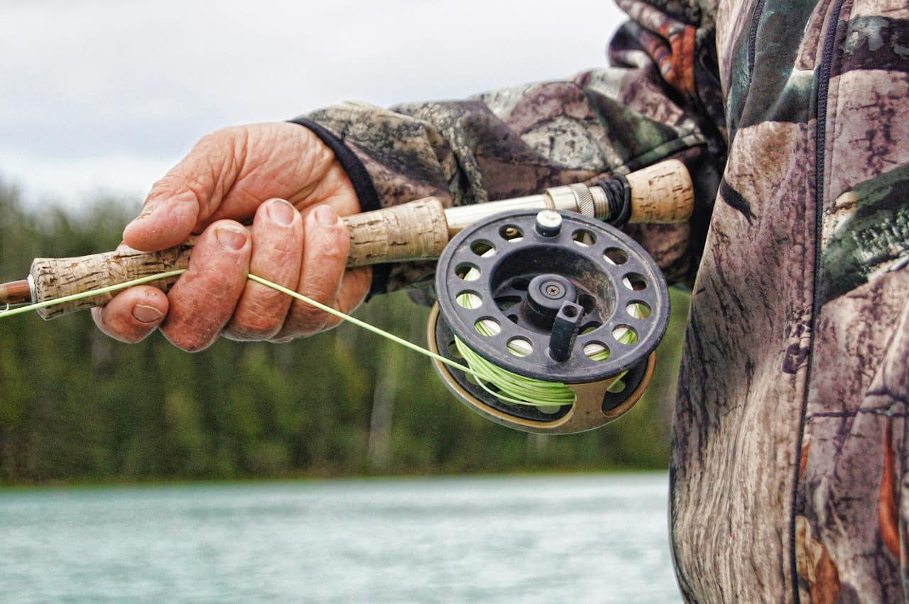 person wearing camouflage clothes holding steering rod 