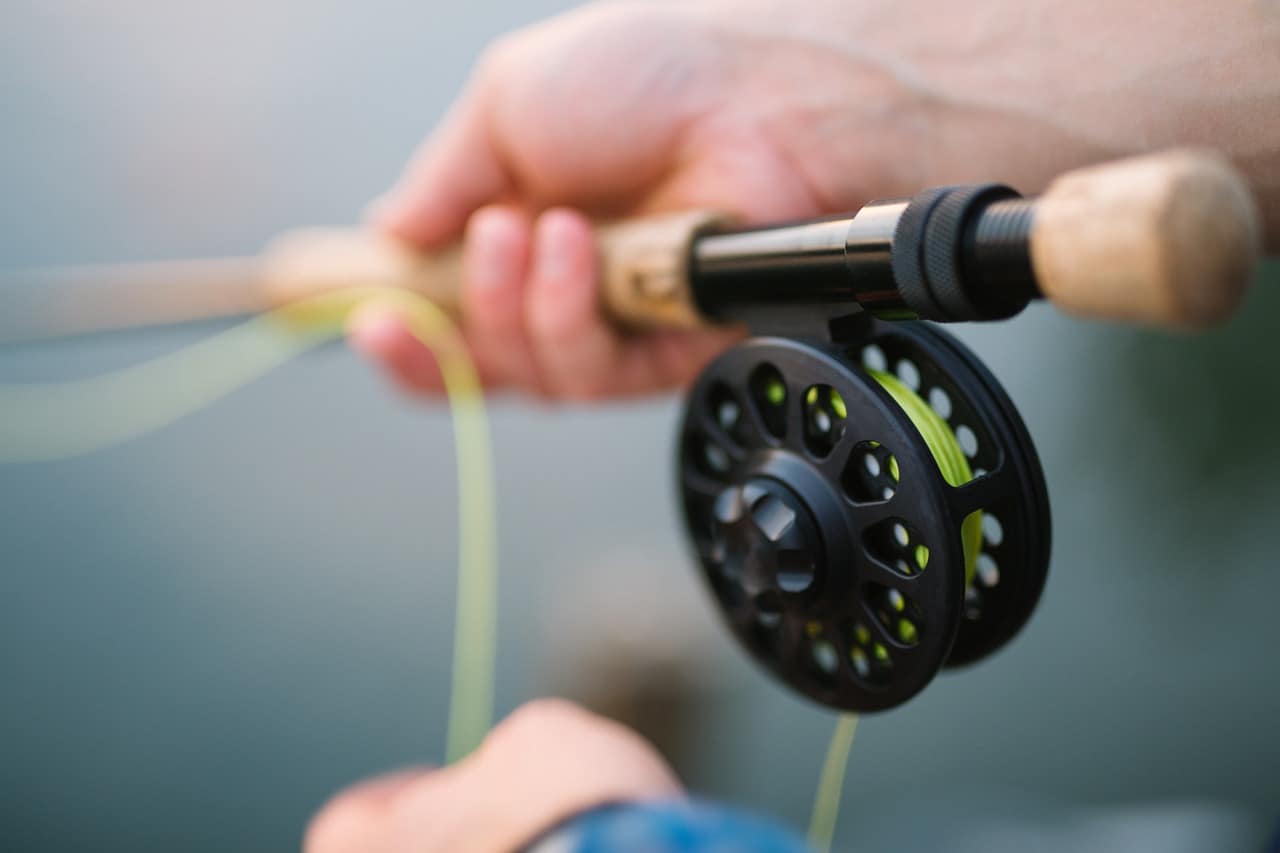 person holding fishing rod with green wire