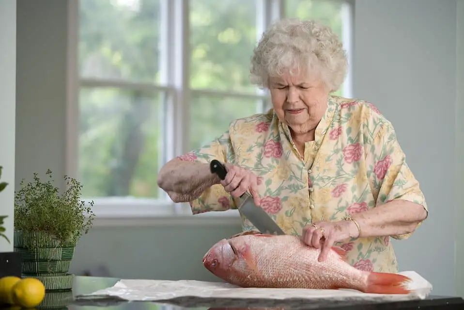 elderly women preparing fresh fish