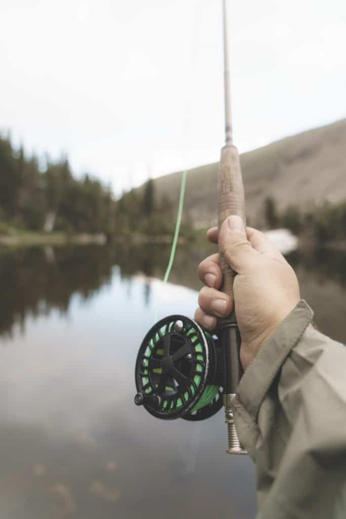 a person showing the handle of a fishing rod